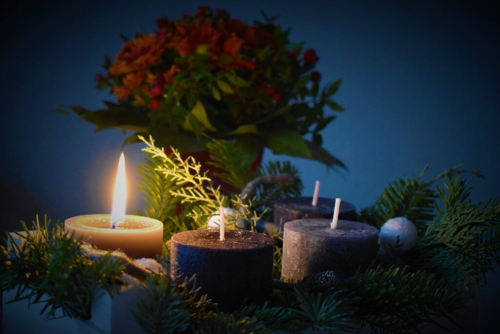 lighted candle beside another 3 candles