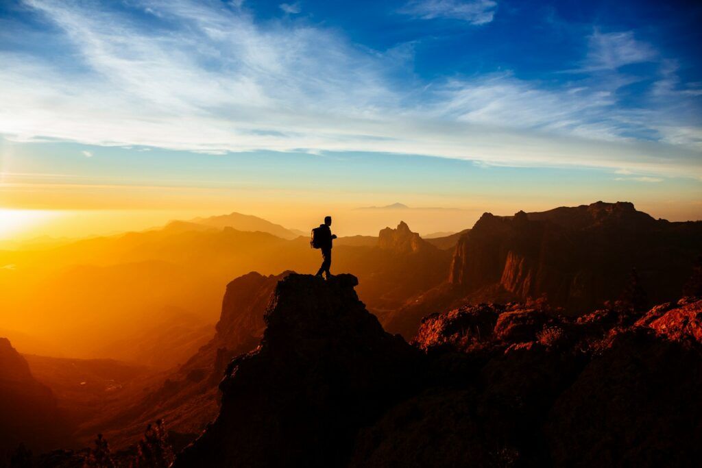 a person standing on top of a mountain at sunset